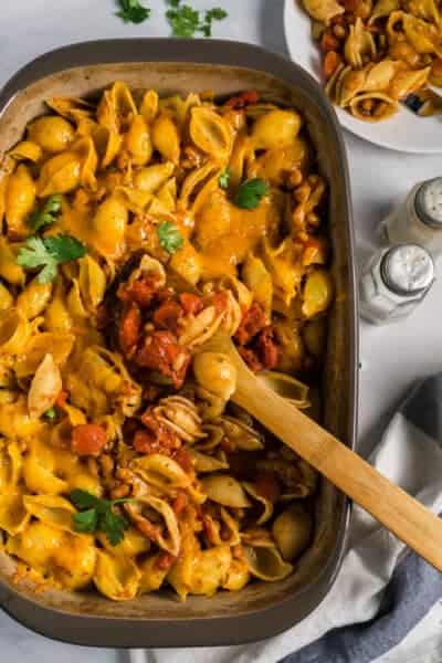 pasta casserole in 9x12 dish with some scooped out onto a plate